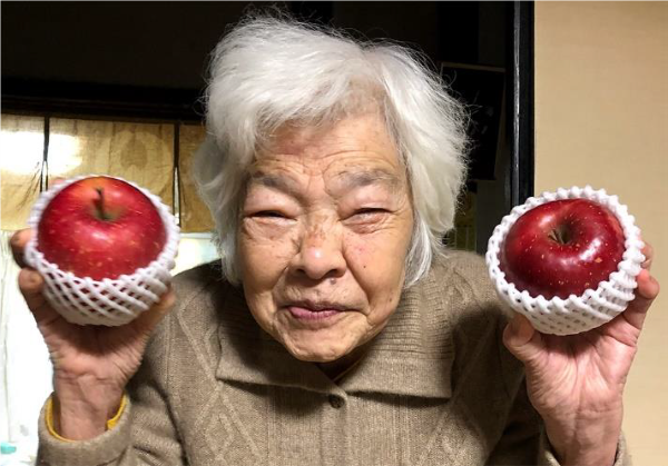 両手にりんごを持つお母さんの写真